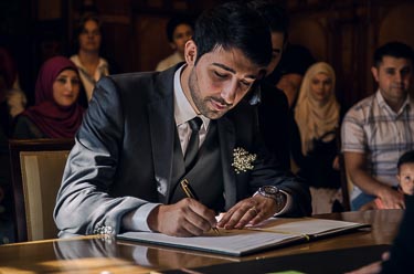 Brautpaar bei der Unterschrift im Standesamt